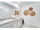 Modern bathroom with double sinks, granite countertops, decorative accents, and large mirror at 7415 Sandstone Dr, Groveland, FL 34736