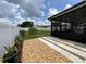 View of fenced backyard from patio, including small tree and garden area from a covered and screened patio at 7601 Fort Sumter Dr, Orlando, FL 32822