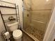 Bright bathroom features a tiled shower with glass doors and a convenient toilet shelf at 7601 Fort Sumter Dr, Orlando, FL 32822