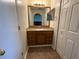 Well-lit bathroom with a wooden vanity, granite countertop, ample storage, and convenient access to closet at 7601 Fort Sumter Dr, Orlando, FL 32822