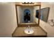Bright bathroom featuring a sink with granite countertops, a large mirror, and convenient towel rack at 7601 Fort Sumter Dr, Orlando, FL 32822