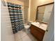 Bathroom features a wooden vanity, mirror, and a colorful striped shower curtain at 7601 Fort Sumter Dr, Orlando, FL 32822
