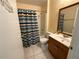Cozy bathroom with a wooden vanity, mirror, and a colorful striped shower curtain at 7601 Fort Sumter Dr, Orlando, FL 32822