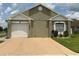 Charming single-story home with a light tan stucco exterior and well-maintained front yard at 7601 Fort Sumter Dr, Orlando, FL 32822
