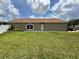 The side of the house has well-kept grass, white fence, and green plants and flowers at 7601 Fort Sumter Dr, Orlando, FL 32822