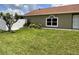 The side of the home features a well-manicured lawn and various plants, with a white fence in back at 7601 Fort Sumter Dr, Orlando, FL 32822