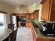 Bright kitchen features stainless steel appliances, brown wood cabinets, granite counters, and a tile backsplash at 7601 Fort Sumter Dr, Orlando, FL 32822