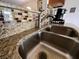Close up of the kitchen sink with stainless steel faucet, decorative backsplash and beautiful granite countertop at 7601 Fort Sumter Dr, Orlando, FL 32822