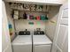 A pair of white laundry machines inside of a laundry closet featuring overhead shelving at 7601 Fort Sumter Dr, Orlando, FL 32822