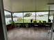 Screened-in patio area has tile flooring, ceiling, chairs, and potted plants with a view of the fenced in backyard at 7601 Fort Sumter Dr, Orlando, FL 32822