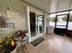 Covered patio looking into kitchen through sliding glass doors, with decorations and plants nearby at 7601 Fort Sumter Dr, Orlando, FL 32822