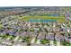 Expansive community view showcases houses, a central pond, and green spaces with a clear sky backdrop at 9024 Alba Ln, Kissimmee, FL 34747