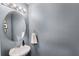 Powder room showcases stylish lighting, vanity, round mirror, and towel holder at 9024 Alba Ln, Kissimmee, FL 34747