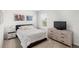 Bedroom with natural light features a dresser with television and modern decor at 9024 Alba Ln, Kissimmee, FL 34747
