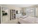 Spacious bedroom featuring a large window, a dresser with shelving, and an open doorway to the kitchen at 9024 Alba Ln, Kissimmee, FL 34747