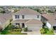Charming two-story home with a well-manicured lawn, covered porch, and attached two-car garage in a vibrant community at 9024 Alba Ln, Kissimmee, FL 34747