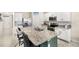 Modern kitchen features granite counters, stainless appliances, white cabinetry, and eat-in kitchen island at 9024 Alba Ln, Kissimmee, FL 34747