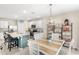 Open kitchen and dining area with stainless appliances, granite countertops, eat-in island, and modern fixtures at 9024 Alba Ln, Kissimmee, FL 34747