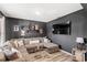 Gathering room displays sectional sofa, modern coffee tables, mounted television and dark walls at 9024 Alba Ln, Kissimmee, FL 34747
