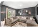 Gathering room displays sectional sofa, modern coffee tables, mounted television and dark walls at 9024 Alba Ln, Kissimmee, FL 34747