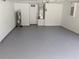 Clean and spacious two-car garage featuring painted walls and epoxy floors at 1027 Sheeler Hills Dr, Apopka, FL 32703