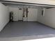 Clean and spacious two-car garage featuring painted walls and epoxy floors at 1027 Sheeler Hills Dr, Apopka, FL 32703
