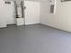 Clean and spacious two-car garage featuring painted walls and epoxy floors at 1027 Sheeler Hills Dr, Apopka, FL 32703