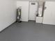 Clean and spacious two-car garage featuring painted walls and epoxy floors at 1027 Sheeler Hills Dr, Apopka, FL 32703