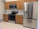 Modern kitchen featuring stainless steel appliances and wooden cabinetry at 1027 Sheeler Hills Dr, Apopka, FL 32703