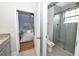 Bathroom with glass-door shower, neutral tile, and view into the primary bedroom at 10275 Henbury St, Orlando, FL 32832