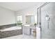Bright bathroom features a soaking tub, walk-in shower, and vanity with granite counters at 10275 Henbury St, Orlando, FL 32832