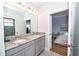 Spacious bathroom with double sinks, granite counters, and a view to the bedroom at 10275 Henbury St, Orlando, FL 32832