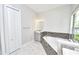 Bright bathroom features a soaking tub, walk-in shower, and marble floors at 10275 Henbury St, Orlando, FL 32832