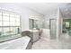 Spacious bathroom boasts a soaking tub, shower, and natural light from the large window at 10275 Henbury St, Orlando, FL 32832