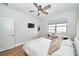 Cozy bedroom with white walls, wood floors, a ceiling fan, and a window with a white frame at 10275 Henbury St, Orlando, FL 32832