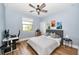 Comfortable bedroom with a gaming setup, ceiling fan, and bright window at 10275 Henbury St, Orlando, FL 32832