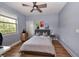 Bedroom with gray comforter, ceiling fan, and two large windows with natural light at 10275 Henbury St, Orlando, FL 32832