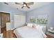 Bedroom with a white comforter, ceiling fan, and large white closets with doors for storage at 10275 Henbury St, Orlando, FL 32832