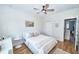 Bright bedroom with a ceiling fan, white walls, wood floors, and a window with a white frame at 10275 Henbury St, Orlando, FL 32832
