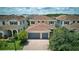 Two-story house showcasing red tile roof, green landscaping, and a brick driveway leading to a two-car garage at 10275 Henbury St, Orlando, FL 32832