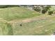 Aerial view of the golf course with golfers at the driving range and a water feature to the side at 10275 Henbury St, Orlando, FL 32832