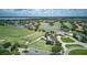 An aerial view of the golf course with putting greens, a water feature, and residences in the background at 10275 Henbury St, Orlando, FL 32832