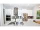 Modern kitchen featuring stainless steel appliances, island with seating, and a view, perfect for cooking and gathering at 10275 Henbury St, Orlando, FL 32832