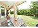 Covered patio with brick pavers and outdoor seating overlooks the lush backyard at 10275 Henbury St, Orlando, FL 32832