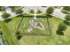 Aerial view of community playground equipment set in grassy fenced area at 10275 Henbury St, Orlando, FL 32832