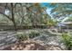 Spacious backyard featuring mature trees, a patio area, and an outdoor dining set with a blue umbrella at 10359 Smyrna Dr, Orlando, FL 32817
