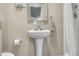 Traditional-style bathroom with a pedestal sink, a tile-framed mirror, and a shower with a curtain at 10359 Smyrna Dr, Orlando, FL 32817