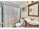 Bathroom with a blue-tiled shower, dark wood vanity, and white shower curtain at 10359 Smyrna Dr, Orlando, FL 32817