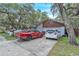 Exterior view of home and driveway featuring two parked cars under a blue sky at 10359 Smyrna Dr, Orlando, FL 32817