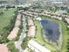 An aerial view of a residential community with a pond and a line of townhouses at 10423 Belfry Cir, Orlando, FL 32832